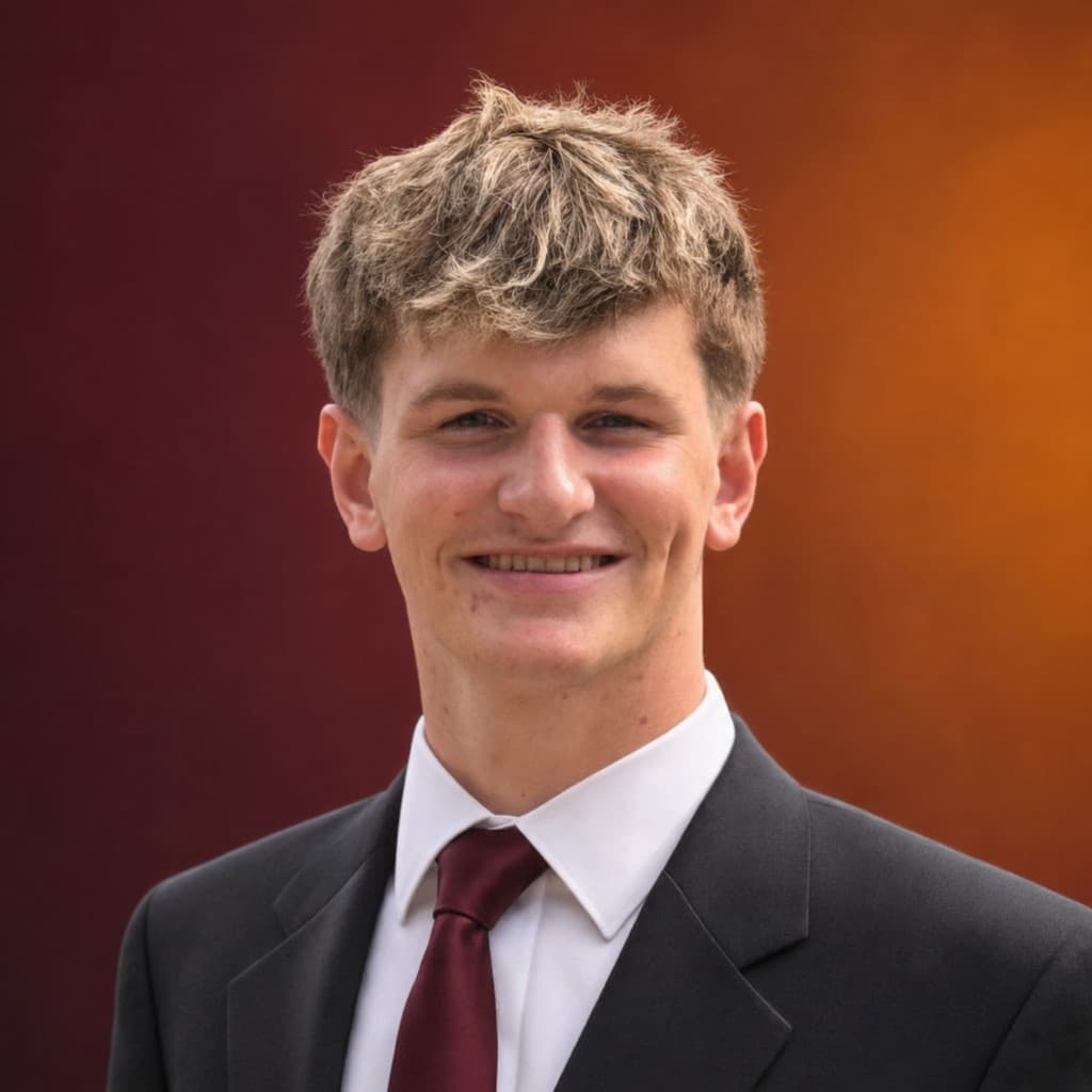 Zach Jenkins smiling in a suit and maroon tie